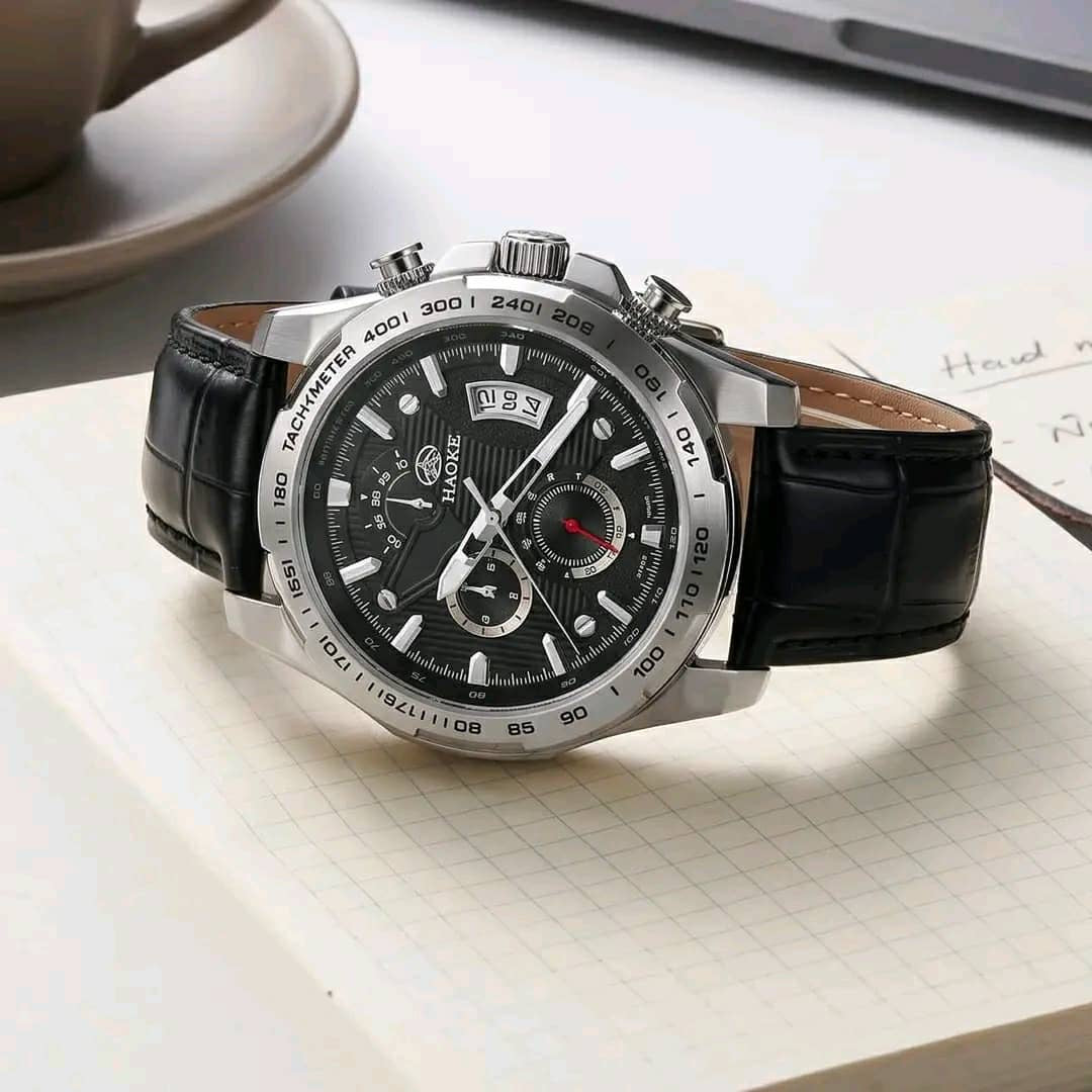 Silver-tone chronograph-style watch with dark dial and brown leather-look strap