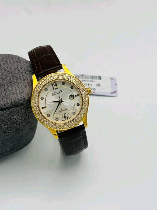 Gold-tone watch with light dial, crystal-style bezel and dark leather strap